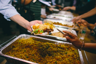 Photo showing Refugees serving food others.